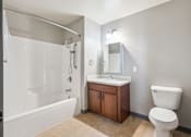 Thumbnail 19 of 25 - A white toilet sits next to a sink in a bathroom.