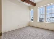 Thumbnail 12 of 21 - Empty room with a window overlooking a cityscape.