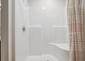 Thumbnail 7 of 23 - A white bathroom with a shower and a shower curtain.