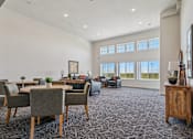 Thumbnail 4 of 23 - A spacious living room with grey chairs and a carpeted floor.