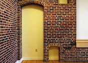 Thumbnail 19 of 27 - A yellow door is in a brick wall.