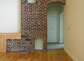 Thumbnail 23 of 27 - A room with a brick wall and a white door.