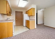 Thumbnail 2 of 12 - A kitchen with wooden cabinets and a white refrigerator.