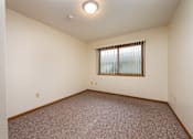 Thumbnail 9 of 12 - A room with a window and carpeted floor.