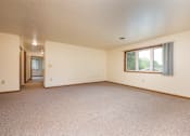 Thumbnail 4 of 12 - A large empty room with a window and a door.