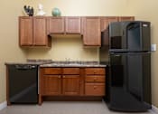 Thumbnail 3 of 17 - A kitchen with a black fridge and a black dishwasher.