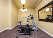 Thumbnail 9 of 17 - A room with a treadmill and exercise bike.