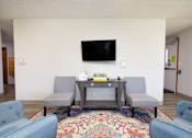 Thumbnail 7 of 20 - A living room with a grey sofa and a television mounted on the wall.