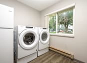 Thumbnail 12 of 20 - A laundry room with a washer and dryer in it.