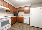 Thumbnail 9 of 20 - A kitchen with white appliances and wooden cabinets.