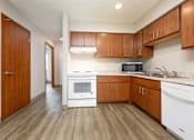 Thumbnail 11 of 20 - A kitchen with wooden cabinets and white appliances.