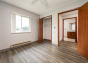 Thumbnail 17 of 20 - A room with wooden floors and a window with blinds.
