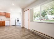 Thumbnail 13 of 20 - A modern kitchen with wooden floors and white appliances.