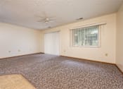 Thumbnail 6 of 14 - A room with a carpeted floor and a ceiling fan.