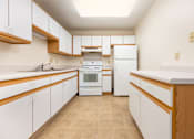 Thumbnail 1 of 14 - A kitchen with white cabinets and a white oven.