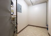 Thumbnail 10 of 14 - A room with a white wall and a brown baseboard heater.