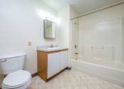 Thumbnail 9 of 14 - A white toilet sits next to a sink in a small bathroom.