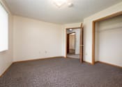 Thumbnail 5 of 14 - A room with a carpeted floor and a doorway leading to another room.