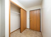 Thumbnail 8 of 14 - A room with a white wall and a brown door.