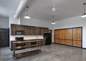 Thumbnail 9 of 22 - A kitchen with wooden cabinets and a stainless steel island.