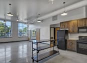 Thumbnail 8 of 22 - A kitchen with a black fridge and wooden cabinets.