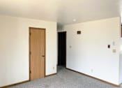 Thumbnail 8 of 9 - an empty living room with a door and white walls