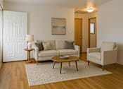 Thumbnail 4 of 11 - A living room with a couch, chair, and coffee table.