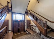Thumbnail 5 of 19 - A staircase with a wooden handrail and a carpeted floor.