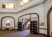 Thumbnail 16 of 19 - A room with a staircase and a bookcase.