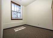 Thumbnail 12 of 19 - A room with a window and a carpet with a white square on it.