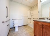 Thumbnail 11 of 19 - A bathroom with a toilet, sink, and bathtub.