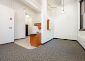 Thumbnail 10 of 19 - A white room with a brown desk and a white fridge.