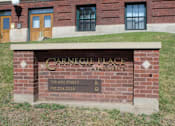 Thumbnail 1 of 19 - A brick wall with a sign that says Carnegie Place Apartments.
