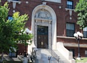 Thumbnail 2 of 19 - A red brick building with a large arched entrance.