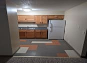 Thumbnail 5 of 10 - A kitchen with a white refrigerator and wooden cabinets.