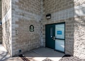 Thumbnail 3 of 14 - A green door is on the right side of the building.