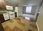 Thumbnail 16 of 28 - A kitchen with brown and tan tiled flooring.