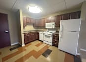 Thumbnail 14 of 28 - A kitchen with white appliances and brown cabinets.