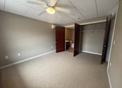 Thumbnail 19 of 28 - A room with a ceiling fan and carpeted floor.