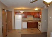 Thumbnail 5 of 11 - A kitchen with white appliances and wooden cabinets.