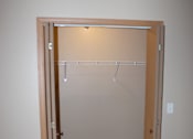 Thumbnail 9 of 11 - A mirror with a wooden frame is hanging on a wall above a wooden shelf.