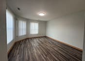 Thumbnail 5 of 11 - A room with wooden flooring and two windows.