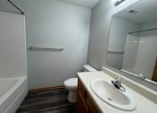 Thumbnail 9 of 11 - A white sink is on a countertop in a bathroom with a toilet and a bathtub.