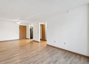 Thumbnail 14 of 20 - A room with wooden floors and white walls with two doors.