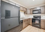 Thumbnail 10 of 20 - A kitchen with a black refrigerator, black oven, and black microwave.