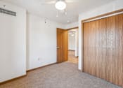 Thumbnail 16 of 20 - A room with a carpeted floor and a wooden door.