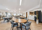 Thumbnail 4 of 20 - A conference room with a large table surrounded by grey chairs.