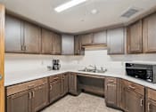 Thumbnail 11 of 20 - A kitchen with wooden cabinets and a white countertop.