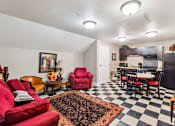 Thumbnail 5 of 17 - A living room with red chairs and a black and white checkered floor.