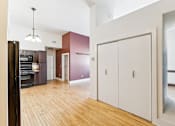 Thumbnail 10 of 17 - A kitchen with wooden floors and white cabinets.
